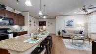 Located in Victoria, TX, this well-appointed 2-bedroom, 2-bathroom single-story residence offers a thoughtfully designed open-concept layout. The kitchen is a standout, featuring rich dark wood cabinetry, granite countertops, a tile backsplash, track lighting, and a breakfast bar with seating — all flowing seamlessly into the dining area and living room. Hardwood-style flooring runs throughout the main living areas, complemented by vaulted ceilings with pendant lighting and a skylight that floods the space with natural light. The living room is bright and welcoming, with large windows, a ceiling fan, and direct sightlines to the dining and kitchen areas. Both bedrooms are carpeted and generously sized, each with ceiling fans and ample natural light from large windows. The primary bedroom offers a comfortable, private retreat. The bathrooms are finished with tile flooring, granite vanities, and tub-shower combinations with decorative tile accents. Additional features include a dedicated laundry room with full-size washer and dryer hookups, three closets for ample storage, a hallway connecting the private spaces, and a patio for outdoor enjoyment.