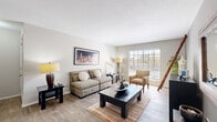 This thoughtfully designed 2-bedroom, 2-bathroom single-story residence offers a functional and comfortable layout across a well-utilized floor plan. Wood-style flooring flows throughout the main living areas, creating a cohesive and warm aesthetic.

The living room is bright and welcoming, featuring a large window that invites natural light and offers outdoor views. It connects seamlessly to the dining area, which is anchored by a chandelier overhead and a sliding glass door that brings in additional light and access to the outdoors. The galley-style kitchen is well-equipped, featuring dark granite-style countertops, taupe cabinetry, black appliances including a range and refrigerator, and a double sink — all oriented to maximize efficiency.

Both bedrooms are carpeted and include ceiling fans with light fixtures and natural light from windows with blinds. Each bedroom features a distinct accent wall — one in a rich blue and the other in a soft purple — adding character and depth to the private spaces. Each bedroom is served by its own bathroom; one bathroom includes a glass-enclosed shower stall with clean white tile finishes.

The residence also includes two closets for additional storage. Neutral wall tones throughout the home create a versatile backdrop, while the consistent wood-style flooring in common areas ties the space together cohesively.