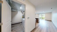 This well-appointed 2-bedroom, 2-bathroom residence in Darien, IL offers a thoughtfully designed single-floor layout with modern finishes throughout. Light wood-tone flooring flows seamlessly across the open-concept kitchen and living area, creating a bright and cohesive atmosphere. The kitchen is a standout feature, boasting warm wood cabinetry, quartz countertops with a subtle veining pattern, a curved center island with an undermount sink, stainless steel appliances, a subway tile backsplash, and elegant pendant lighting. The living area benefits from a sliding glass door that invites natural light and provides outdoor views of lush greenery. Both bedrooms feature light hardwood floors, neutral walls, and sliding glass door or window access to natural light; the primary bedroom includes a dedicated closet. The two bathrooms are finished with marble-style tile on floors and walls — one features a walk-in glass-enclosed shower, while the other offers a full tub-shower combination, both with wood-toned vanities and backlit mirrors. A dedicated laundry room houses a full-size washer and dryer. The home combines clean, contemporary design with practical amenities for comfortable everyday living.