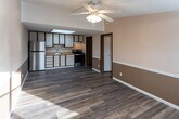 Located at 1000 Lakeshore Dr in Fort Oglethorpe, Georgia, this single-floor home offers a practical and functional layout with a warm, neutral color palette throughout. The open-concept living area flows seamlessly into the kitchen, both finished with durable laminate wood flooring and accented by two-tone walls in soft beige and white. Ceiling fans with light fixtures are present in the main living spaces, providing both comfort and illumination. Natural light enters through windows, brightening the interior.

The kitchen is well-equipped with cream-colored cabinetry trimmed in dark wood, light-toned countertops, a stainless steel sink, a stainless steel refrigerator, and an electric range, offering ample storage and counter space for everyday cooking needs.

The bedroom features the same laminate flooring, a ceiling fan, and a built-in closet with bifold doors, providing convenient storage. The bathroom includes a full tub and shower combination with chrome fixtures. A dedicated laundry room houses a full-size washer and dryer alongside a water heater, adding practical utility to the home. Textured ceilings are consistent throughout, completing the cohesive and functional character of this property.