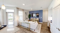 Located in Katy, TX, this well-appointed single-story home offers 2 bedrooms and 2 bathrooms within a thoughtfully designed open-concept floor plan. The kitchen is a standout feature, showcasing crisp white shaker cabinetry, granite countertops, subway tile backsplash, stainless steel appliances, and wood-look flooring — all bathed in natural light from a large window. A built-in desk nook with cabinetry and granite surface provides a dedicated workspace just off the living area. The living room is anchored by a bold blue accent wall and flows seamlessly into the bright dining area, which is surrounded by windows offering pleasant outdoor views. The primary bedroom features a ceiling fan, natural light, and its own en-suite bathroom complete with a double-sink granite vanity, a large framed mirror, and a tiled tub-shower combo. The second bedroom is generously sized with a ceiling fan and direct access to a full bathroom with matching finishes. Two closets provide ample storage throughout the home. The consistent use of neutral tones, granite surfaces, and wood-look flooring creates a cohesive, modern aesthetic across the entire space.