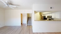 This two-story residence offers a well-organized layout across both levels, designed for comfortable everyday living. The main floor features light hardwood-style flooring throughout the open living and dining areas. The kitchen is equipped with stainless steel appliances — including a refrigerator, range, microwave, and dishwasher — complemented by granite countertops, a pass-through window, and crisp white cabinetry providing ample storage. The spacious living room is a standout, featuring a tile-surround fireplace, a ceiling fan, and sliding glass doors that open to an outdoor area, allowing natural light to fill the room. A dedicated laundry area with a full-size washer and dryer is conveniently located on the main level. A bathroom with a tub-shower combination and wood-style flooring is also found on this floor. Upstairs, the carpeted bedrooms are generously sized, each benefiting from ceiling fans and large windows that bring in natural light and outdoor views. The upper-level bathrooms mirror the clean, neutral aesthetic of the rest of the home, each featuring a tub-shower combination, a vanity with a large mirror, and hardwood-style flooring. Throughout, the home maintains a bright, neutral palette that creates a clean and welcoming atmosphere.