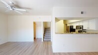 This two-story residence offers a well-organized layout across both levels, designed for comfortable everyday living. The main floor features light hardwood-style flooring throughout the open living and dining areas. The kitchen is equipped with stainless steel appliances — including a refrigerator, range, microwave, and dishwasher — complemented by granite countertops, a pass-through window, and crisp white cabinetry providing ample storage. The spacious living room is a standout, featuring a tile-surround fireplace, a ceiling fan, and sliding glass doors that open to an outdoor area, allowing natural light to fill the room. A dedicated laundry area with a full-size washer and dryer is conveniently located on the main level. A bathroom with a tub-shower combination and wood-style flooring is also found on this floor. Upstairs, the carpeted bedrooms are generously sized, each benefiting from ceiling fans and large windows that bring in natural light and outdoor views. The upper-level bathrooms mirror the clean, neutral aesthetic of the rest of the home, each featuring a tub-shower combination, a vanity with a large mirror, and hardwood-style flooring. Throughout, the home maintains a bright, neutral palette that creates a clean and welcoming atmosphere.
