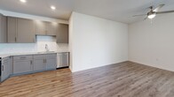 Located at 811 Rosery Rd NW in Largo, FL, this 2-bedroom, 2-bathroom single-floor residence offers a thoughtfully designed layout that maximizes both comfort and functionality. The open-concept living, dining, and kitchen area serves as the heart of the home, featuring warm wood-look luxury vinyl plank flooring, crisp white walls, and a ceiling fan that enhances the bright, airy atmosphere. The kitchen is well-equipped with gray shaker-style cabinetry extending to the ceiling, granite countertops, a white subway tile backsplash, stainless steel appliances, and a dedicated pantry for added storage. Both bedrooms are carpeted and filled with natural light from multiple windows offering outdoor views. The primary bedroom includes a spacious walk-in closet outfitted with wire shelving across multiple walls. The bathrooms are finished with granite-topped gray vanities, wood-look flooring, and a soaking tub with white subway tile surround. Additional conveniences include in-unit laundry, a hallway with additional closets, and access to a private balcony. The overall ambiance is clean, modern, and move-in ready.