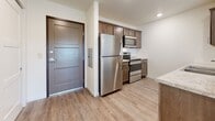 Located at 201 24th Ave SE in Willmar, Minnesota, this single-floor residence offers a clean, contemporary design with thoughtfully selected finishes throughout. The open living area is anchored by plush carpet flooring, a ceiling fan with light fixture, and generous windows that invite abundant natural light and views of the surrounding neighborhood. A glass door provides additional access and further enhances the bright, airy atmosphere of the main living space.

The kitchen is efficiently designed in a galley layout, featuring rich dark-stained cabinetry with brushed nickel hardware, granite-style countertops, a stainless steel sink, and a full suite of stainless steel appliances including a refrigerator, range, microwave, and dishwasher. Light wood-look flooring ties the kitchen and entry areas together seamlessly.

The bedrooms are carpeted and well-lit by sliding windows with outdoor views. Closet space is provided via sliding-door closets with built-in shelving and hanging rods. The bathroom includes a single-sink vanity with dark wood cabinetry and white countertop, a full tub and shower combination, and wood-look flooring. The overall aesthetic is modern, neutral, and move-in ready, offering functional comfort in a residential Willmar setting.