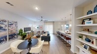 Located at 2213 Cascades Ave, this single-story residence features three bedrooms and two bathrooms within a thoughtfully designed open-concept floor plan. The combined kitchen and living area serves as the central hub of the home, where light wood-style flooring, recessed lighting, and a ceiling fan contribute to a bright, contemporary atmosphere. A sliding glass door floods the living space with natural light and provides outdoor access.

The kitchen is well-appointed with dark shaker-style cabinetry, granite countertops, stainless steel appliances, and an extended island with pendant lighting and bar seating — ideal for casual dining or entertaining. A built-in shelving wall and dedicated mudroom nook with hooks, a bench, and overhead storage add practical organization near the entryway.

The primary bedroom features a walk-in closet, ceiling fan, and an accent wall, while an en-suite bathroom offers a granite vanity with navy cabinetry. A second bedroom includes direct bathroom access, also finished with a dark vanity and granite countertop. Carpet in the bedrooms contrasts comfortably with the hard flooring throughout the main living areas, creating a cohesive and functional home.