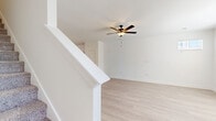 Located in the Black Forest Road corridor of Colorado Springs, CO, this two-story home offers a thoughtfully designed layout spread across two floors. The main level is anchored by a bright, open-concept living room and kitchen combination. The living area features light-toned luxury vinyl plank flooring, a ceiling fan with integrated light, large windows that invite natural light, and direct access to a private patio. The kitchen stands out with crisp white cabinetry, a classic subway tile backsplash, a marble-look center island with pendant lighting, and a full suite of stainless steel appliances including a dishwasher, range, microwave, and French door refrigerator. A full bathroom and utility room round out the main floor.

Upstairs, the primary bedroom offers comfortable carpeting, a ceiling fan, and a window with natural light. Three closets—including a walk-in with wire shelving—provide generous storage throughout. The second full bathroom features a marble-look double vanity, wood-framed mirror, and a tub/shower combination with clean white surround. A staircase with white-painted railings connects both levels, reinforcing the home's clean, modern aesthetic throughout.