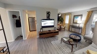 This single-floor residence offers a thoughtfully designed open layout that connects the living, dining, and kitchen areas seamlessly. The living room is generously proportioned, featuring wood-look plank flooring, neutral gray walls, and large sliding glass doors that flood the space with natural light and provide access to an outdoor patio. The adjoining dining area is anchored by a ceiling fan and window with warm yellow drapes, creating a welcoming atmosphere.

The kitchen is efficiently arranged with white shaker-style cabinetry, granite-look countertops, stainless steel appliances including a refrigerator, dishwasher, and built-in microwave, plus recessed lighting overhead. Wood-look flooring continues throughout the main living areas for a cohesive feel.

The two bedrooms offer a comfortable retreat, each with plush carpeting and softly lit, understated décor. Both bathrooms maintain a clean, modern aesthetic with white tile surrounds, tub-shower combinations, granite-look vanity countertops, and wood-look flooring. The layout provides convenient access between all areas of the home, making the overall flow practical and intuitive. This residence balances functional design with a warm, inviting ambiance suitable for everyday living.