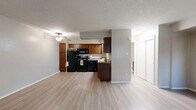 Located at 1332 SW 74th St in Oklahoma City, Oklahoma, this single-floor unit offers a practical and well-organized layout across a compact footprint. Light wood-look flooring runs throughout the space, providing a clean and cohesive aesthetic, while textured ceilings add a classic residential character.

The open-concept main area seamlessly combines the living room, dining space, and kitchen into one connected zone. The kitchen is well-appointed with rich warm-toned cabinetry, granite-look countertops, a full suite of black appliances including a refrigerator, range, built-in microwave, and dishwasher, and a sink positioned along the counter. A ceiling fan overhead serves both the kitchen and living areas, promoting comfortable airflow. A central structural column defines the kitchen's boundary without closing off the space.

The living area is bright and open, receiving natural light through a window, and features baseboard heating along the walls as well as a wall-mounted AC unit, ensuring year-round climate control. A six-panel entry door provides direct access from outside.

The bedroom area offers two closets — one a sliding-door style — delivering ample storage. The bathroom is clean and functional, featuring a bathtub, toilet, and towel fixtures. The unit's efficient design makes thoughtful use of every square foot.
