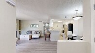 Located in Tucson, Arizona, this single-story 2-bedroom, 2-bathroom residence offers a thoughtfully designed layout across a comfortable footprint. The living room serves as the heart of the home, highlighted by a wood-burning fireplace, light hardwood-style flooring, and a striking arched window that fills the space with natural light. Neutral tones and a textured ceiling contribute to the room's warm, inviting ambiance.

The kitchen features a galley-style configuration with white shaker cabinetry, light stone countertops, wood-look flooring, and stainless steel appliances including a refrigerator, range, and dishwasher, providing both functionality and a clean, modern aesthetic.

The spacious primary bedroom is carpeted and offers generous room for furnishings, with windows that allow natural light and direct access to a hallway leading to the closet area. The second bedroom is equally comfortable, also carpeted, with a closet and a window overlooking the outdoors.

Both bathrooms are finished with white cabinetry, stone-look countertops, and light wood-style tile flooring. The primary bathroom features a well-lit vanity mirror with modern fixture lighting, while the second bathroom offers a compact, efficient layout. A connecting hallway ties all rooms together in a practical and cohesive floor plan.