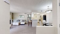 Located in Tucson, Arizona, this single-story 2-bedroom, 2-bathroom residence offers a thoughtfully designed layout across a comfortable footprint. The living room serves as the heart of the home, highlighted by a wood-burning fireplace, light hardwood-style flooring, and a striking arched window that fills the space with natural light. Neutral tones and a textured ceiling contribute to the room's warm, inviting ambiance.

The kitchen features a galley-style configuration with white shaker cabinetry, light stone countertops, wood-look flooring, and stainless steel appliances including a refrigerator, range, and dishwasher, providing both functionality and a clean, modern aesthetic.

The spacious primary bedroom is carpeted and offers generous room for furnishings, with windows that allow natural light and direct access to a hallway leading to the closet area. The second bedroom is equally comfortable, also carpeted, with a closet and a window overlooking the outdoors.

Both bathrooms are finished with white cabinetry, stone-look countertops, and light wood-style tile flooring. The primary bathroom features a well-lit vanity mirror with modern fixture lighting, while the second bathroom offers a compact, efficient layout. A connecting hallway ties all rooms together in a practical and cohesive floor plan.