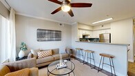 This single-floor, 2-bedroom, 2-bathroom residence in Phoenix, Arizona offers a thoughtfully designed layout that maximizes comfort and functionality. The open-concept living and dining area is anchored by wood-look flooring and crown molding, with a ceiling fan adding a practical touch. A breakfast bar connects the living space to the kitchen, which features crisp white cabinetry, a teal subway tile backsplash, stainless steel appliances including a refrigerator and range, and ample counter space. A dedicated dining area provides additional flexibility for everyday living. The living room opens to a private balcony through sliding glass doors, inviting natural light and outdoor views. A central hallway connects the bedrooms and bathrooms, maintaining a clear and efficient flow throughout. The primary bedroom is generously sized with plush carpeting, a ceiling fan, a large window, and direct access to a walk-in closet. The bathrooms are well-appointed with white cabinetry, gray countertops, a full tub-shower combination, and wood-look flooring. Additional storage is provided by two closets. The dining nook doubles as a versatile flex space with mirrored walls that enhance the sense of openness. Covered parking is available on-site.