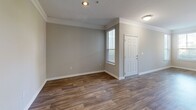 Located at 1575 Ridenour Pky in Kennesaw, GA, this three-bedroom, three-bathroom townhome spans three well-defined floors, offering a functional and comfortable layout throughout. The entry level includes a garage with an automatic opener, a utility area, and convenient access to the main living spaces. Rich hardwood-style flooring flows through the entry and main living areas, complemented by neutral gray walls and crisp white trim and crown molding details. The main level features an open-concept layout combining the living room, dining area, and kitchen. The kitchen is equipped with dark cabinetry, a peninsula with countertop seating, a tile backsplash, and track lighting, making it a practical hub for daily living. Bedrooms are carpeted and generously sized, with ceiling fans and multiple windows that invite natural light and offer views of surrounding greenery. The spacious primary bedroom includes ample room and is supported by one of eight closets throughout the home—several featuring wire shelving systems for organized storage. Bathrooms are finished with clean white tile surrounds and standard fixtures. A balcony provides outdoor access, while the laundry room adds everyday convenience. With three staircases connecting the floors, this home is designed for ease of movement and practical multi-level living.