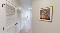 Located at 1820 Silas Deane Highway in Rocky Hill, CT, this well-appointed 2-bedroom, 2-bathroom residence offers a bright and modern single-floor layout designed for comfortable everyday living. Light hardwood flooring flows throughout the main living areas, tying together the open-concept kitchen, dining, and living spaces.

The kitchen is a standout feature, showcasing white shaker cabinetry, stainless steel appliances, a subway tile backsplash, and a large center island with pendant lighting and bar seating — ideal for both meal prep and casual entertaining. The adjacent dining area benefits from large windows with horizontal blinds that invite generous natural light. The living room continues this airy aesthetic with recessed lighting and additional windows overlooking the exterior.

A welcoming hallway connects the living spaces to the private quarters, featuring louvered closet doors and decorative touches. The primary bedroom is a comfortable retreat with plush carpeting and ample closet space. The second bedroom, also carpeted, includes a double-door closet and bright windows. Both bathrooms are finished in neutral tones — one featuring a walk-in glass shower with white cabinetry and matte black fixtures, the other offering a full tub/shower combination. Four closets throughout the unit ensure excellent storage.
