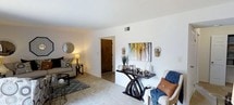 This 2-bedroom, 1-bathroom residence is thoughtfully designed across a single floor, offering a practical and comfortable layout. The living area serves as the heart of the home, featuring neutral wall-to-wall carpeting that adds warmth underfoot, and crisp white walls that create a bright, clean backdrop throughout. The space is generously proportioned, providing ample room for both lounging and entertaining. A central hallway connects the living area to the private quarters, ensuring a smooth and functional flow throughout the unit. The living room benefits from well-placed accent lighting and features a decorative wall display area, lending a polished, curated feel to the space. Smooth white ceilings and a neutral color palette keep the interiors feeling open and airy, while a HVAC vent ensures year-round climate comfort. The overall ambiance is welcoming and move-in ready, with clean lines and a versatile design that easily accommodates a variety of furnishing styles. This residence strikes a balance between practicality and comfort, making it an ideal home for those seeking a well-organized, single-level living experience.