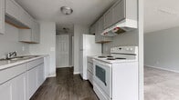 Located at 2660 Chili Ave in Rochester, NY, this one-bedroom, one-bathroom unit offers a practical and efficiently designed single-floor layout. The entry foyer welcomes you with dark hardwood-style flooring and a large sliding-door closet, providing generous storage right at the entrance.

The galley-style kitchen is well-equipped with gray shaker cabinetry, marble-patterned countertops, a built-in sink, and white appliances including an electric range, refrigerator, and dishwasher. A textured ceiling and overhead lighting complete the functional cooking space, which flows conveniently toward the rest of the unit.

The living area is spacious and bright, featuring plush neutral carpeting, baseboard heating, and multiple windows that allow natural light to fill the room. The open layout provides flexibility for various furniture arrangements.

The primary bedroom offers a comfortable footprint with soft carpet, a window overlooking greenery, baseboard heating, and a sliding-door closet for ample storage.

The full bathroom includes a single-sink vanity with gray cabinetry, a full-size soaking tub with a tiled surround, and built-in shelving niches. Throughout the unit, the neutral gray color palette and clean finishes create a cohesive, move-in-ready atmosphere.