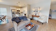 Located at 9 Covered Bridge Rd, this single-floor residence offers a thoughtfully designed open-concept layout that seamlessly connects the kitchen, dining, and living areas. The kitchen is a standout feature, showcasing white shaker-style cabinetry, granite countertops, a classic subway tile backsplash, a center island with bar seating, pendant lighting, and a full suite of stainless steel appliances including a gas range, microwave, and French door refrigerator. The living area is bright and welcoming, with light hardwood-style flooring and a sliding glass door that opens onto a private outdoor balcony, offering pleasant views of the surrounding natural landscape. The bedrooms are generously sized, each with large windows that fill the rooms with natural light and the same warm flooring found throughout the unit. The space includes two bathrooms: a full bath featuring a soaking tub, tiled flooring, and a dark espresso vanity, and a second bath with a similar vanity and clean, neutral finishes. Neutral wall tones, crisp white trim, and consistent flooring create a cohesive and modern aesthetic throughout, making this a comfortable and move-in-ready residence.