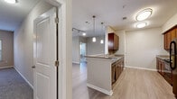 This single-story residence offers a well-designed layout with a neutral color palette and consistent finishes throughout. The kitchen serves as a central focal point, featuring rich dark-wood cabinetry, granite-style countertops with a tile backsplash, and a peninsula with pendant lighting that connects the space to the open living area. Black appliances, including a range and refrigerator, complement the cabinetry, while light wood-style flooring flows throughout the main living and kitchen areas.

The living space is open and airy, benefiting from the kitchen's pass-through peninsula design. Bedrooms are carpeted and include ceiling fans, generous natural light from multiple windows, and walk-in closets outfitted with wire shelving systems offering ample storage capacity. The unit includes two full bathrooms: one with a tub-shower combination and tiled surround, and another featuring a longer vanity with dark-wood cabinetry and a large mirror. Both bathrooms are finished with light ceramic tile flooring. Additional storage is provided through well-sized closets throughout the unit, contributing to the overall functional and comfortable character of the space.