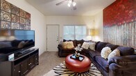This thoughtfully designed one-bedroom, one-bathroom residence offers a comfortable and functional layout across a single floor. The open-concept living and kitchen area forms the heart of the home, where the living room features plush carpeting, a ceiling fan, and natural light streaming through blinds-covered windows. The kitchen is well-equipped with rich dark wood cabinetry, granite-style countertops, black appliances including a gas range, refrigerator, and dishwasher, along with tile flooring and a ceiling fan overhead. An in-unit washer and dryer area is conveniently located just off the kitchen. The bedroom is a generously sized retreat, carpeted for comfort, and featuring a ceiling fan, a large window with natural light, and direct access to a spacious walk-in closet outfitted with wire shelving and ample hanging space. The bathroom continues the cohesive design with rich wood cabinetry, a framed vanity mirror, tile flooring, and a clean, neutral color palette throughout. Warm, neutral tones are carried consistently across every room, creating a cohesive and inviting ambiance throughout the entire residence.