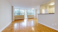 Located at 890 Mount Pleasant in Toronto's desirable Midtown neighbourhood, this 2-bedroom unit offers a well-designed layout across a single floor. The open-concept living and dining area is bright and spacious, featuring classic parquet wood flooring that extends throughout the entire unit. Large floor-to-ceiling windows flood the space with natural light while framing expansive views of the surrounding cityscape. A sliding glass door leads to a private balcony, perfect for taking in the urban panorama.

The kitchen is positioned adjacent to the living area, separated by a half-wall pass-through counter that maintains an open and connected feel. It is equipped with stainless steel appliances, including a full-size refrigerator and an electric range, complemented by white cabinetry and tiled flooring.

The primary bedroom is generously proportioned, featuring built-in closets with double doors, parquet flooring, and neutral walls that provide a calm retreat. The second bedroom is comfortably sized with its own window, baseboard heating, and the same warm parquet flooring. The textured ceilings and clean white trim throughout lend a consistent, polished finish to the entire unit.
