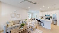 Located at 100 Hatchett Creek Blvd in Venice, Florida, this well-appointed 2-bedroom, 1-bathroom home offers a thoughtfully designed single-level layout filled with natural light and contemporary finishes throughout. Light-toned luxury vinyl plank flooring flows seamlessly across the entire space, lending a clean, cohesive aesthetic.

The open-concept living, dining, and kitchen area forms the heart of the home. The living room features a ceiling fan, recessed lighting, and sliding glass doors that open onto a private balcony, bringing in abundant natural light and outdoor views. The kitchen is outfitted with crisp white shaker cabinetry, quartz countertops, stainless steel appliances, and a peninsula with bar seating — ideal for casual dining. The adjacent dining area includes a large window overlooking the outdoors, creating a bright and inviting atmosphere.

The primary bedroom is generously proportioned, with a ceiling fan and ample natural light. The second bedroom offers a cozy retreat with a bright window and light-filled ambiance. The full bathroom is finished with a white single-vanity, quartz countertop, a large framed mirror, and a glass-enclosed walk-in shower. A dedicated closet provides additional storage. The overall palette of soft whites and neutrals gives the entire home a calm, airy Florida feel.