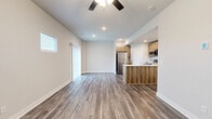 This two-story home in Kansas City, MO offers a well-designed layout across two floors, combining modern finishes with practical functionality. The main level features an open-concept kitchen and living area with wood-look luxury vinyl plank flooring, recessed lighting, and a ceiling fan. The kitchen is equipped with stainless steel appliances, including a refrigerator, range, and microwave, complemented by warm wood-toned cabinetry, a subway tile backsplash, and a peninsula with a white quartz countertop and undermount sink — ideal for both cooking and casual dining. A half bath on the main floor adds convenience for guests. The staircase, featuring dark metal balusters and carpet treads, connects to the upper level, where three bedrooms await. The spacious primary bedroom includes a ceiling fan and a dedicated bathroom with a wide vanity, white quartz countertop, and a large mirror. Secondary bedrooms are carpeted and filled with natural light from windows with outdoor views. Each bathroom carries a consistent, clean aesthetic with wood-toned cabinetry and vinyl plank flooring. The home also includes an attached garage with a concrete floor, a utility room, three closets, and a hallway that ties the upper floor together efficiently.