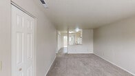 Located at 1845 Leslie Rd in Richland, WA, this two-bedroom residence offers a thoughtfully organized single-floor layout with functional living spaces throughout. The kitchen is well-appointed with ample white cabinetry, light-toned countertops, a full suite of white appliances including a refrigerator, electric range, and dishwasher, and durable wood-style flooring. A sliding glass door leads directly from the kitchen area to a private balcony, bringing in natural light and outdoor greenery views. The primary bedroom is generously sized, featuring plush carpet, a double sliding-door closet, and direct access to a private bathroom equipped with a vanity, mirror, and a bathtub. The second bedroom is comfortably proportioned, also carpeted, and includes a closet and a window that allows natural light to filter in. Neutral, warm-toned walls throughout the unit create a clean and cohesive aesthetic. The layout, as seen in the dollhouse view, is compact yet efficiently designed, making excellent use of the available floor area. The overall ambiance is bright, practical, and move-in ready, suitable for those seeking a comfortable residence in the Richland area.