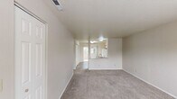 Located at 1845 Leslie Rd in Richland, WA, this two-bedroom residence offers a thoughtfully organized single-floor layout with functional living spaces throughout. The kitchen is well-appointed with ample white cabinetry, light-toned countertops, a full suite of white appliances including a refrigerator, electric range, and dishwasher, and durable wood-style flooring. A sliding glass door leads directly from the kitchen area to a private balcony, bringing in natural light and outdoor greenery views. The primary bedroom is generously sized, featuring plush carpet, a double sliding-door closet, and direct access to a private bathroom equipped with a vanity, mirror, and a bathtub. The second bedroom is comfortably proportioned, also carpeted, and includes a closet and a window that allows natural light to filter in. Neutral, warm-toned walls throughout the unit create a clean and cohesive aesthetic. The layout, as seen in the dollhouse view, is compact yet efficiently designed, making excellent use of the available floor area. The overall ambiance is bright, practical, and move-in ready, suitable for those seeking a comfortable residence in the Richland area.