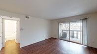 Located on Pershall Road in Saint Louis, MO, this single-floor unit offers a straightforward and functional layout with consistent wood-style flooring extending throughout every room. The living area is the focal point of the space, characterized by clean white walls, a ceiling-mounted ventilation system, and a full-width sliding glass door that opens directly onto a private outdoor balcony. The balcony provides outdoor views of surrounding trees, adding a natural element to the interior ambiance.

The layout includes a separate bedroom area featuring a large window with vertical blinds that allows natural light to fill the room, along with a built-in closet offering practical storage. An additional room with a closet is accessible from the main living space, providing flexibility for various uses.

The kitchen is equipped with warm-toned wooden cabinetry, light countertops, a stainless steel sink, and a dishwasher. A louvered bifold door conceals additional storage or utility space nearby. The bathroom includes a full tub-shower combination with chrome fixtures set against clean white surroundings. Overall, the unit presents a neutral, well-maintained interior suitable for a variety of living arrangements.