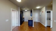 This 2-bedroom, 2-bathroom residence is thoughtfully laid out across a single floor, offering a cohesive and efficient use of space. The open-concept living and dining area features rich wood-style flooring that flows throughout the main living spaces, complemented by neutral-toned walls and ceiling fans that enhance comfort and airflow. Natural light filters in through multiple windows, creating a bright and welcoming atmosphere.

The kitchen is equipped with dark cabinetry, granite-style countertops, a double-basin stainless steel sink, and black appliances including a refrigerator and range. A peninsula with a raised breakfast bar connects the kitchen to the living area, adding both functionality and a natural gathering point.

Both bedrooms are generously sized, each featuring ceiling fans, windows with natural light, and ample closet space with built-in shelving. The carpeted bedrooms provide a comfortable contrast to the hard flooring found throughout the rest of the unit.

The two bathrooms are identically appointed, each offering a tub-shower combination, a dark-vanity with a single sink, a large mirror, tile flooring, and brushed nickel hardware accents. The overall design is clean, practical, and consistent throughout, making this a well-appointed and move-in-ready residence.