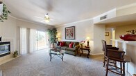 This single-floor residence at 6455 Timber Bluff Pt in Colorado Springs, Colorado offers a well-organized layout with distinct living, sleeping, and functional zones. The living room serves as the focal point of the home, featuring plush carpeting, crown molding, a ceiling fan with light fixture, and a fireplace. Large sliding glass doors open to a private balcony, allowing abundant natural light and outdoor views to fill the space. The room flows naturally toward a dining area, creating an open and connected feel.

The kitchen is efficiently designed with wood-look flooring, white cabinetry, a stainless steel over-the-range microwave, an electric range, and a dishwasher. Ample cabinetry provides generous storage throughout.

The two bedrooms are carpeted and well-lit by multiple windows. The primary bedroom is notably spacious, accommodating a full bedroom suite with room to spare, and features an adjoining bathroom. A second bedroom offers similar natural light and comfortable proportions.

The bathrooms include wood-look vinyl flooring and clean, white tiled tub-shower combinations. Overall, the residence presents a warm, functional living environment well-suited to the Colorado Springs setting.