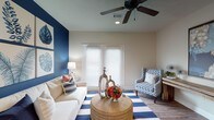 Located at 2889 Sollie Rd in Mobile, Alabama, this single-floor home offers a thoughtfully designed layout with cohesive coastal-inspired décor and bold navy blue accent walls that create visual interest throughout. The living room serves as a welcoming centerpiece, featuring French doors with plantation shutters that allow for natural light, wood-look flooring, and a ceiling fan overhead. The dining area is an elegant space adorned with large-scale artwork, hardwood-style flooring, and a classic chandelier, creating an inviting atmosphere for entertaining. The kitchen is well-equipped with rich dark wood cabinetry, granite countertops, stainless steel appliances, and wood-look flooring, with convenient access to a dedicated laundry area and pantry. The bedrooms offer plush carpeting, ceiling fans, and large windows dressed with plantation shutters and curtains, each accented by a striking navy blue feature wall. The primary bathroom includes a double-sink granite vanity, soaking tub with shower combination, and tile flooring, while a second full bathroom also provides a tub-shower combo and granite vanity. Together, these spaces combine practical functionality with a consistent, design-forward aesthetic.