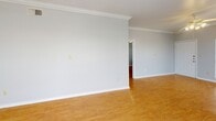 Located at 2904 Swisher St in Austin, TX, this single-floor, 2-bedroom, 2-bathroom home offers a well-designed layout with consistent hardwood-style flooring throughout the main living areas. The open living room is bright and welcoming, featuring soft blue accent walls, crown molding, a ceiling fan with light fixture, and multiple windows that invite generous natural light and outdoor views. The space flows seamlessly toward the kitchen, which is equipped with light wood cabinetry, a dishwasher, a stainless steel refrigerator, a tile floor, and ample counter space. The primary bedroom is generously sized, featuring large dual windows, crown molding, a ceiling fan, and a built-in desk shelf — ideal for a home office setup. It also includes a closet for dedicated storage. The second bedroom continues the hardwood-style flooring with its own ceiling fan and a bright window. Both bathrooms are clean and functional, with one featuring a full tub and shower combination with white tile surround. A dedicated in-unit laundry closet with a full-size washer and dryer adds everyday convenience. Crown molding and ceiling fans are consistent throughout, contributing to a cohesive and comfortable interior throughout the home.