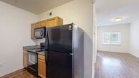 This one-bedroom, one-bathroom unit offers a well-organized single-floor layout that makes efficient use of its compact footprint. Wood-style flooring flows consistently throughout every room, lending a cohesive and warm aesthetic to the entire space.

The living room is bright and open, featuring white walls, clean lines, and a window fitted with horizontal blinds that allows natural light to filter in. A sliding glass door provides access to an outdoor balcony, adding a welcome extension to the living area and enhancing the sense of openness.

The galley-style kitchen is thoughtfully equipped, featuring warm honey-toned cabinetry, granite-look countertops, and a full suite of black appliances including a refrigerator, electric range, and over-the-range microwave. A double-basin sink with a window above it adds functionality and a touch of natural light to the cooking space.

The bedroom is a cozy, well-defined room with a ceiling fan, a reach-in closet with sliding doors, and white walls that keep the space feeling clean and neutral.

The bathroom features a tub-shower combination with tiled surround, a granite-topped vanity with undermount sink, warm wood cabinetry, and brushed nickel hardware, maintaining a consistent, polished finish throughout the unit.