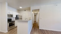 Located at 340 Shadow Ridge Grove in Colorado Springs, CO, this two-bedroom, three-bathroom residence offers a well-designed single-floor layout with a clean, modern aesthetic throughout. The open-concept kitchen and dining area serves as the heart of the home, featuring white shaker-style cabinetry, stainless steel appliances, granite countertops, and a peninsula island with a built-in sink — ideal for both meal preparation and casual dining. Wood-style plank flooring runs through the main living areas, complementing the bright, neutral color palette and recessed lighting overhead. The living room is a comfortable and airy space, highlighted by a ceiling fan with light fixture and a glass door leading to a private balcony. The balcony overlooks a landscaped community courtyard with mature trees and mountain sky views — a standout feature of this Colorado Springs location. Both bedrooms are carpeted and filled with natural light through vertical-blind-covered windows, with generous closet storage. Four closets total provide ample organization throughout. The three bathrooms each include tub/shower combinations with classic white tile surrounds. Additional conveniences include an in-unit laundry area and a central hallway connecting all rooms efficiently. This residence offers a practical and comfortable layout in a well-maintained community setting.