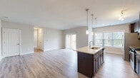 This thoughtfully designed 2-bedroom, 2-bathroom residence in Perry Hall, Maryland offers a comfortable and modern living experience across a single floor. The open-concept kitchen and living area serves as the heart of the home, anchored by a large center island with granite countertops, an undermount sink, and elegant pendant lighting. Dark espresso cabinetry contrasts beautifully with light wood-style flooring, while stainless steel appliances—including a gas range, microwave, and French door refrigerator—add a polished touch. A glass tile backsplash and abundant natural light from oversized windows complete the kitchen's inviting atmosphere. Sliding glass doors lead to an outdoor area, seamlessly connecting indoor and outdoor living. The spacious primary bedroom features plush carpeting, multiple windows with outdoor views, and a walk-in closet equipped with wire shelving. The second bedroom is equally comfortable with soft carpeting and clean, neutral tones. Both bathrooms are finished with tile flooring, dark vanity cabinetry, and a sliding glass-enclosed shower. Throughout the residence, neutral wall tones and consistent finishes create a cohesive, contemporary ambiance.