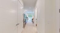 Located at 812 W Adams St in Chicago's vibrant West Loop neighborhood, this thoughtfully designed studio offers a clean, modern aesthetic throughout its efficiently organized single-floor layout. Light hardwood flooring runs continuously from the entry hallway through the living area, creating a seamless and airy feel.

The entry corridor is flanked by tall, flush-panel white cabinetry providing generous storage, leading naturally into the open-concept kitchen and living space. The kitchen is appointed with high-gloss white cabinetry extending to the ceiling, stainless steel appliances including a French door refrigerator, gas range, built-in microwave, and dishwasher, all complemented by marble-style quartz countertops and a single-basin undermount sink.

The living area is bright and open, anchored by floor-to-ceiling sliding glass doors that flood the space with natural light and offer direct access to an outdoor terrace with lush tree-lined views. Recessed lighting throughout adds to the clean, contemporary ambiance.

The bathroom features a floating vanity with a white quartz countertop, a large wall mirror, tile flooring in warm neutral tones, and a walk-in shower with tile surround — all finished in a crisp, minimalist style that complements the rest of the unit.
