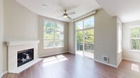 Located in Redmond, WA, this two-story, 2-bedroom, 2-bathroom home offers a thoughtfully organized layout spread across two levels. The main living floor features an open-concept dining, kitchen, and living area bathed in natural light from large windows and a sliding glass door that opens to a private balcony with lush tree views. The living room includes a fireplace and ceiling fan, while durable wood-style flooring flows throughout. The modern kitchen is outfitted with white cabinetry, quartz countertops, a matte black sink with pull-down faucet, and a full suite of stainless steel appliances. Both bathrooms are finished with white vanities and quartz countertops; one features a tub-shower combo, and the other includes a walk-in shower. The bedrooms are carpeted and well-lit, each with a ceiling fan and closet. The primary bedroom is generously sized with multiple windows overlooking the neighborhood. A carpeted staircase connects the floors, and the lower level includes an entrance and an attached garage with built-in shelving and a water heater. Additional conveniences include in-unit laundry and multiple closets for ample storage throughout.