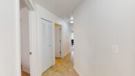 This single-floor residence offers a thoughtfully organized layout that balances comfort and practicality across its key living areas. The kitchen is equipped with rich mahogany-toned cabinetry, granite-style countertops, and a full suite of stainless steel appliances including a range, over-the-range microwave, and refrigerator. A window provides natural light, making the space bright and inviting. Warm-toned tile flooring extends throughout the kitchen, hallways, and bathroom, providing a cohesive and easy-to-maintain surface.

The living room features plush carpeting, multiple windows, and sliding glass door access that brings in generous natural light and outdoor views. The adjacent dining area benefits from vaulted ceiling height and a chandelier overhead, adding an elegant touch to everyday meals. A large window frames views of surrounding greenery, enhancing the room's airy atmosphere.

The bedrooms are carpeted and serene, with clean white walls, ample closet storage — including a walk-in closet in the primary bedroom — and windows that allow for natural light. The hallway features a louvered closet door, adding additional storage. The bathroom includes tile flooring, a vanity with granite-style countertops, and a shower-tub combination, completing this functional and comfortable home.