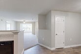 Located at 3624 Belmont St in Greensboro, NC, this single-floor, 2-bedroom, 2-bathroom home offers a well-organized and functional layout. The open-concept kitchen and dining area is a standout feature, showcasing rich dark wood cabinetry, granite countertops, a peninsula breakfast bar, and wood-look flooring with track lighting overhead. Black appliances, including a refrigerator, range, and microwave, complete the kitchen. The living room flows naturally from the kitchen, featuring plush carpet, a ceiling fan, and a window that invites natural light. The spacious primary bedroom includes generous closet space with wire shelving systems, and the additional bedroom is equally well-sized, with its own ceiling fan, carpeted floors, and a bright window. Both bathrooms are finished with wood-look flooring, granite-topped vanities with dark cabinetry, and tub-shower combinations equipped with grab bars. Four closets throughout the home provide ample storage, while a dedicated laundry area adds everyday convenience. Neutral tones, textured ceilings, and white panel doors maintain a clean, cohesive aesthetic throughout this move-in-ready Greensboro home.