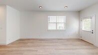 Located at 2165 Casablanca Way in Knoxville, Tennessee, this contemporary two-story home offers a clean, modern aesthetic throughout. Light-toned wood flooring flows consistently across both levels, complementing the crisp white walls and bright, airy atmosphere found in every room.

The main floor houses the kitchen and living area alongside a garage. The kitchen is a standout feature, showcasing an expansive island with taupe quartz-style countertops, white shaker cabinetry with matte black hardware, a subway tile backsplash, and a full suite of stainless steel appliances including a French door refrigerator and range. Sleek pendant lighting adds a modern touch above the island.

The upper floor accommodates three bedrooms, each benefiting from natural light through well-placed windows. The generously sized primary bedroom features vaulted ceilings with a ceiling fan, adding to the sense of spaciousness. Additional bedrooms are bright and well-proportioned. The six bathrooms are finished with white subway tile surround tub-shower combos, matte black fixtures, and wood-look flooring. Each bedroom includes its own closet. A hallway connects the upper-level rooms, and the attached garage provides additional utility space with a water heater on-site.