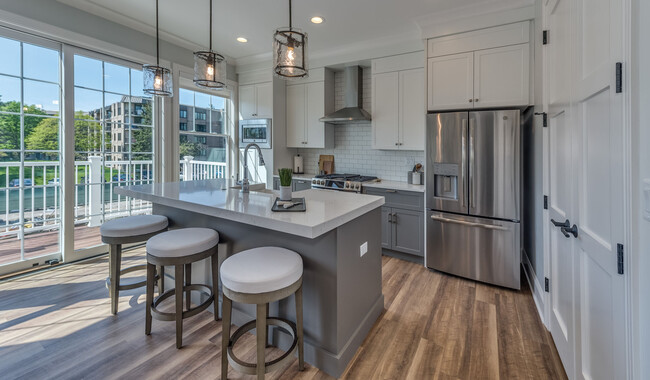 Kitchens feature stone countertops and stainless steel appliances. - Eldridge Townhomes