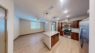 Located at 7521 N Tule Springs Rd in Las Vegas, NV, this well-appointed one-bedroom, one-bathroom unit offers a thoughtfully designed open-concept layout. The kitchen is a standout feature, showcasing rich walnut-toned cabinetry, striking marble-style countertops, a central island with pendant lighting overhead, and a full suite of stainless steel appliances including a gas range, microwave, dishwasher, and refrigerator with ice and water dispenser. Light wood-style flooring flows throughout the main living area, enhancing the bright and airy atmosphere complemented by recessed lighting and ceiling fans. The open living area provides a generous, flexible space bathed in natural light from sizable windows dressed with blinds. The bedroom is carpeted for comfort and features its own ceiling fan, a window for natural light, and direct access to a dedicated walk-in closet outfitted with wire shelving. The bathroom includes a full soaking tub and shower combination with a curved rod and chrome fixtures. The overall design balances modern finishes with a clean, neutral palette, creating a comfortable and functional living environment.