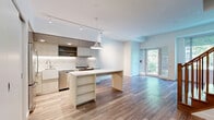 Located at 55 Quebec Ave in Toronto's vibrant Junction neighbourhood, this two-storey home offers three bedrooms, three bathrooms, and a thoughtfully designed layout spread across two floors. The main level features an open-concept kitchen and living area finished with light hardwood-style flooring. The contemporary kitchen is a standout, boasting two-tone cabinetry, a patterned tile backsplash, stainless steel appliances including a farmhouse sink and gas range, under-cabinet lighting, and a central island with built-in shelving — ideal for both cooking and casual dining. The living area is bright and airy, with large windows and a walk-out door that frames lush greenery and outdoor views, while roller shades provide privacy as needed. Upstairs, the three bedrooms are well-proportioned and finished with wood-style flooring and crisp white walls. The primary bedroom benefits from a large picture window overlooking the neighbourhood. Each of the three bathrooms is finished in a clean, modern style featuring large-format tile flooring, a dual-sink vanity with under-mount basins and light wood cabinetry, and minimalist fixtures. Multiple hallways connect the spaces efficiently across both levels, creating a functional and cohesive flow throughout the home.