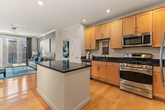 Gourmet kitchens with wood cabinets, granite countertops, and stainless steel appliances - The Reserve at Tysons Corner