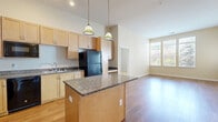 This well-designed two-bedroom, three-bathroom residence in Denver, Colorado offers a thoughtfully organized single-floor layout. The open-concept kitchen and living area serves as the heart of the home, featuring warm hardwood flooring, light maple cabinetry, granite countertops, and a central island with pendant lighting. Black appliances—including a range, built-in microwave, dishwasher, and refrigerator—complement the kitchen's modern aesthetic. A built-in desk nook adds functional versatility to the space.

The living area extends naturally from the kitchen, bathed in natural light through large windows with views of surrounding greenery. Both bedrooms are carpeted and generously sized; the primary bedroom offers ample square footage with a dedicated closet. The second bedroom also benefits from large windows that invite natural light and outdoor views.

All three bathrooms are finished with tile flooring and include accessibility features such as stainless steel grab bars, making the space inclusive and practical. Tub/shower combinations with full tile surrounds are present in the bathrooms. Two dedicated laundry areas provide added convenience. Throughout, neutral tones and consistent finishes create a cohesive and comfortable living environment.