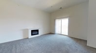 Located at 400 Haslet St in Dover, Delaware, this single-floor residence offers a clean, modern aesthetic throughout its well-designed layout. The living area is a standout feature, showcasing plush gray carpeting that adds warmth and comfort underfoot. A sleek, built-in electric fireplace with a crisp white surround serves as an elegant focal point, providing both visual appeal and a cozy atmosphere. Large sliding glass doors bathe the room in natural light while offering direct access to a private balcony with railing — ideal for enjoying the outdoors. The neutral, light-toned walls and smooth ceilings create a bright, open ambiance that complements the spacious feel of the interior. The overall design is contemporary and understated, making it a versatile canvas well-suited for a variety of furnishing styles. The single-floor layout ensures easy accessibility and seamless flow throughout the home. This residence combines functional design with comfortable living, making it a welcoming and practical space in the heart of Dover, DE.