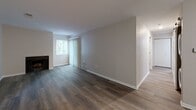 This single-floor unit at 431 Chasseral Dr NW in Comstock Park, Michigan, offers a well-designed layout with a neutral color palette throughout. The main living area features durable wood-look plank flooring, a ceiling fan, and a warm-toned entry door, creating a welcoming and functional space. A fireplace and large window with vertical blinds add character to the living room, allowing natural light to filter through with views of surrounding greenery.

The kitchen is equipped with rich, dark-stained cabinetry, light granite-style countertops, and stainless steel appliances including an electric range and over-the-range microwave, providing a practical and modern cooking environment.

A standout feature is a curved bay area with multiple tall windows that frame outdoor wooded views, offering an abundance of natural light and a distinctive architectural element. This space is finished with plush carpeting, adding warmth underfoot.

The bathroom includes wood-look tile flooring, a full soaking tub, and a tiled shower surround in earthy, varied tones with brushed nickel fixtures. An additional bathroom area features light plank flooring and a closet with built-in wire shelving. Overall, the unit presents a clean, move-in ready environment with consistent finishes throughout.