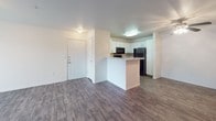This single-floor residence offers a practical and comfortable layout designed for everyday living. The open-concept living and kitchen area forms the heart of the home, where wood-style flooring flows seamlessly from the entry through the main living space. A sliding glass door floods the living area with natural light and provides views of the outdoors through vertical blinds.

The kitchen is efficiently designed around a peninsula that separates it from the living space, featuring white shaker-style cabinetry, light granite-look countertops, and a full suite of black appliances including a refrigerator, electric range with oven, over-the-range microwave, and dishwasher — providing everything needed for functional meal preparation.

The bedrooms are carpeted for comfort and warmth, each featuring natural light from windows with blinds. Select bedrooms include ceiling fans with integrated lighting, and closet space is provided for storage.

Two full bathrooms serve the residence, each equipped with a tub-shower combination, toilet, and a vanity with light stone-pattern countertops. Tile flooring adds a clean, polished look to each bathroom.

Overall, the space presents a clean, neutral palette throughout, with white walls and trim creating a bright, move-in-ready environment that is both functional and inviting.