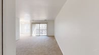Located at 8732 Town and Country Blvd in Ellicott City, MD, this 1-bedroom, 1-bathroom residence offers a thoughtfully arranged single-floor layout designed for comfortable everyday living. The spacious living room is bathed in natural light, thanks to large sliding glass doors fitted with vertical blinds that open directly onto a private balcony — an ideal spot to enjoy outdoor views. Soft wall-to-wall carpeting extends throughout the living areas and bedroom, lending a warm, cohesive feel to the interior. The open layout seamlessly connects the living room to the dining area, while a separate kitchen features warm wood-toned cabinetry. The generously sized bedroom benefits from natural light through a large window and includes access to two closets, one of which is a walk-in with built-in shelving and hanging rods for ample storage. The full bathroom is finished with white tile flooring, a tub-shower combination, and a wood-vanity with a clean white countertop. A connecting hallway ties the rooms together efficiently. The clean, neutral palette throughout creates a bright, move-in-ready environment well-suited to a variety of living styles.